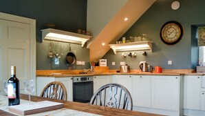 A kitchen with a dining table, chairs, and various kitchen appliances. - 3 bedroom accommodation in Westward, near Wigton (Westward, near Wigton)