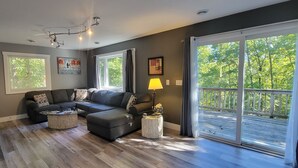A modern living room with a sectional sofa, a coffee table, and a balcony with a railing. - 2 Bedroom, 2 Bath Hot Tub home in the Galena Territory (Galena)
