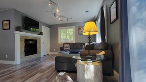 A living room with a fireplace, a sofa, a coffee table, and a lamp. - 2 Bedroom, 2 Bath Hot Tub home in the Galena Territory (Galena)