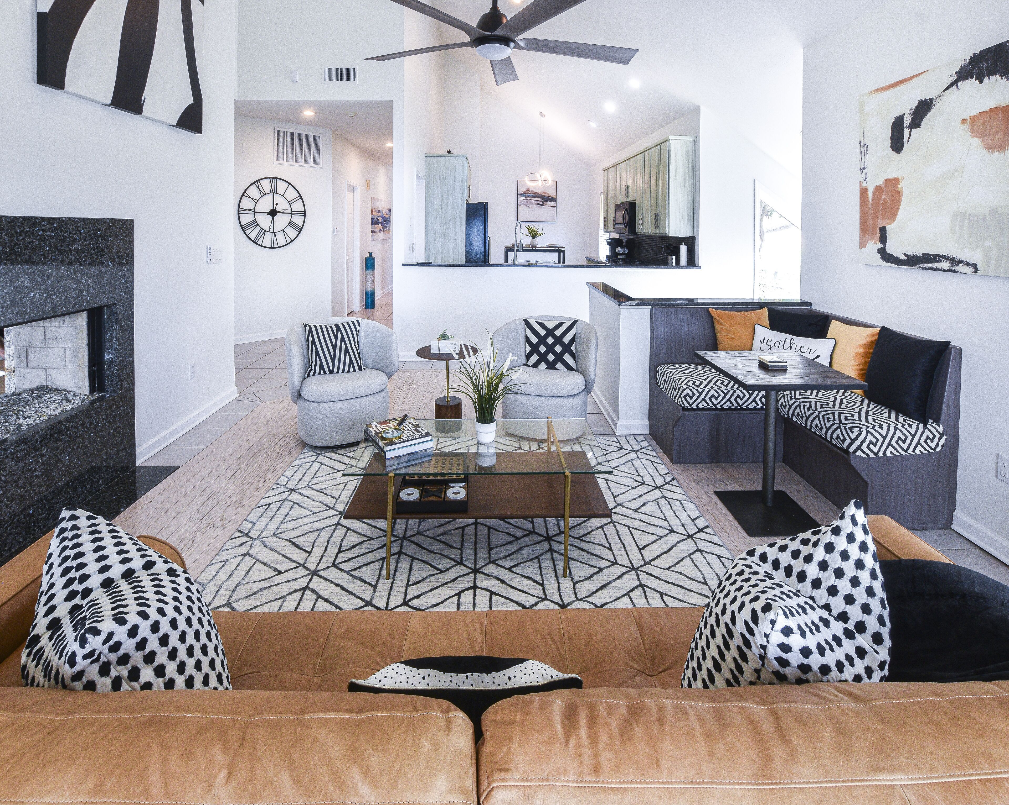 A modern living room with a sofa, armchairs, a coffee table, and a fireplace.