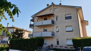 A multi-story residential building with balconies, a flat roof, and a clear sky. - Cosy apartment for 4 guests with A/C, WIFI, TV and panoramic view, close to Porto Recanati (Campanari)