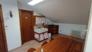 A small kitchen with a wooden door, a sink, and a radiator. - Cosy apartment for 4 guests with A/C, WIFI, TV and panoramic view, close to Porto Recanati (Campanari)