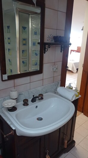 Bathroom features a sink, mirror, and towel, with a door with a geometric pattern.