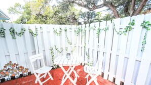 A patio with a white fence, red brick flooring, and white outdoor furniture. - Studio In♥of DT Ft Lauderdale☆Walk 2 restaurants (Fort Lauderdale)