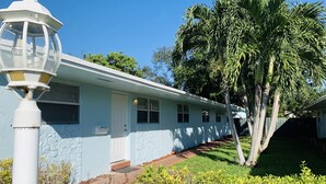 A single-story building with a light blue exterior, a white door, and a small window. - Studio In♥of DT Ft Lauderdale☆Walk 2 restaurants (Fort Lauderdale)