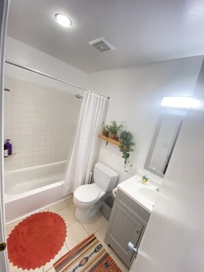 Tina con regadera, jabón, papel de baño 