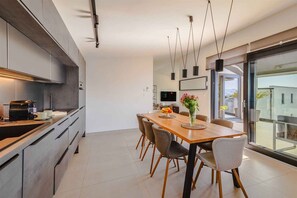 Cozinha moderna com área de refeições, janelas amplas e vista para o exterior.