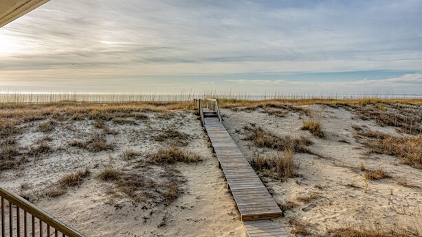A wooden boardwalk leading to a beach with a clear sky. - Ocean Front and beach access to West Bald Head at the Wetmore House! Pet Friendly! (Bald Head Island)