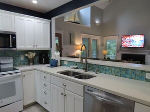 A modern kitchen with white cabinets, a stainless steel sink, and a dishwasher.