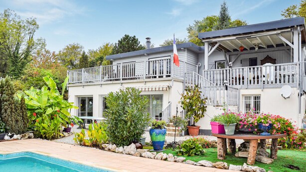 A two-story house with a swimming pool, surrounded by various plants and flowers. - Nice apartment in Chambornay-Lès-Pin (Chambornay-Lès-Pin)