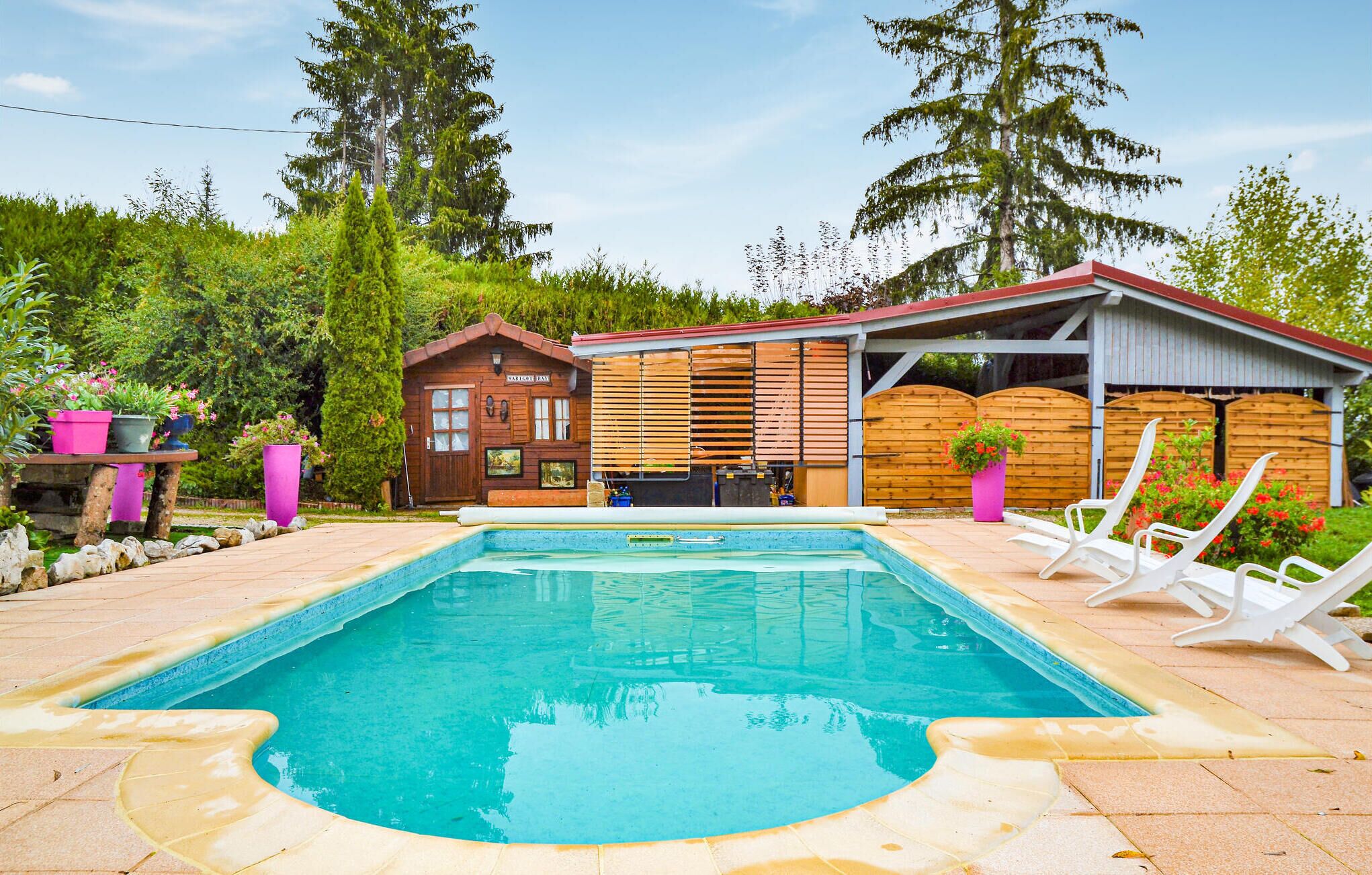 A wooden cabin with a swimming pool, surrounded by lush greenery and trees.
