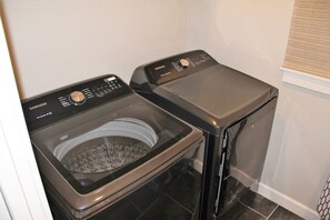A compact laundry room with two front-loading washing machines.