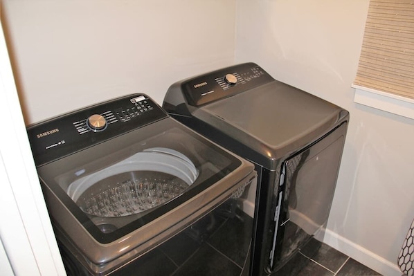 A compact laundry room with two front-loading washing machines.