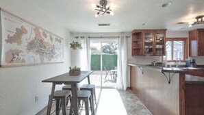 Een keuken met een eethoek, houten kastjes en een kaart aan de muur.