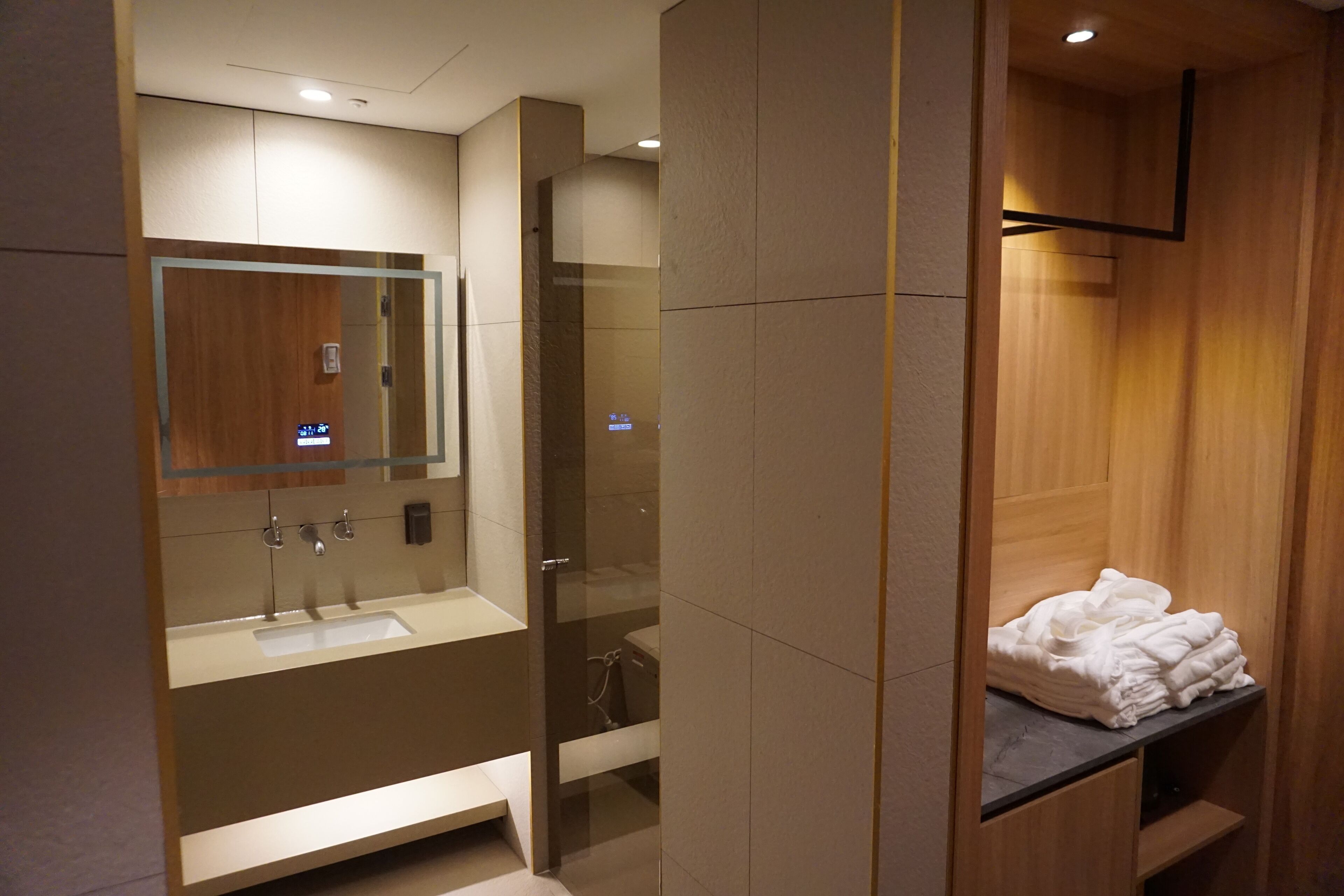 A modern bathroom with a glass-enclosed shower, a vanity with a sink, and a towel rack.
