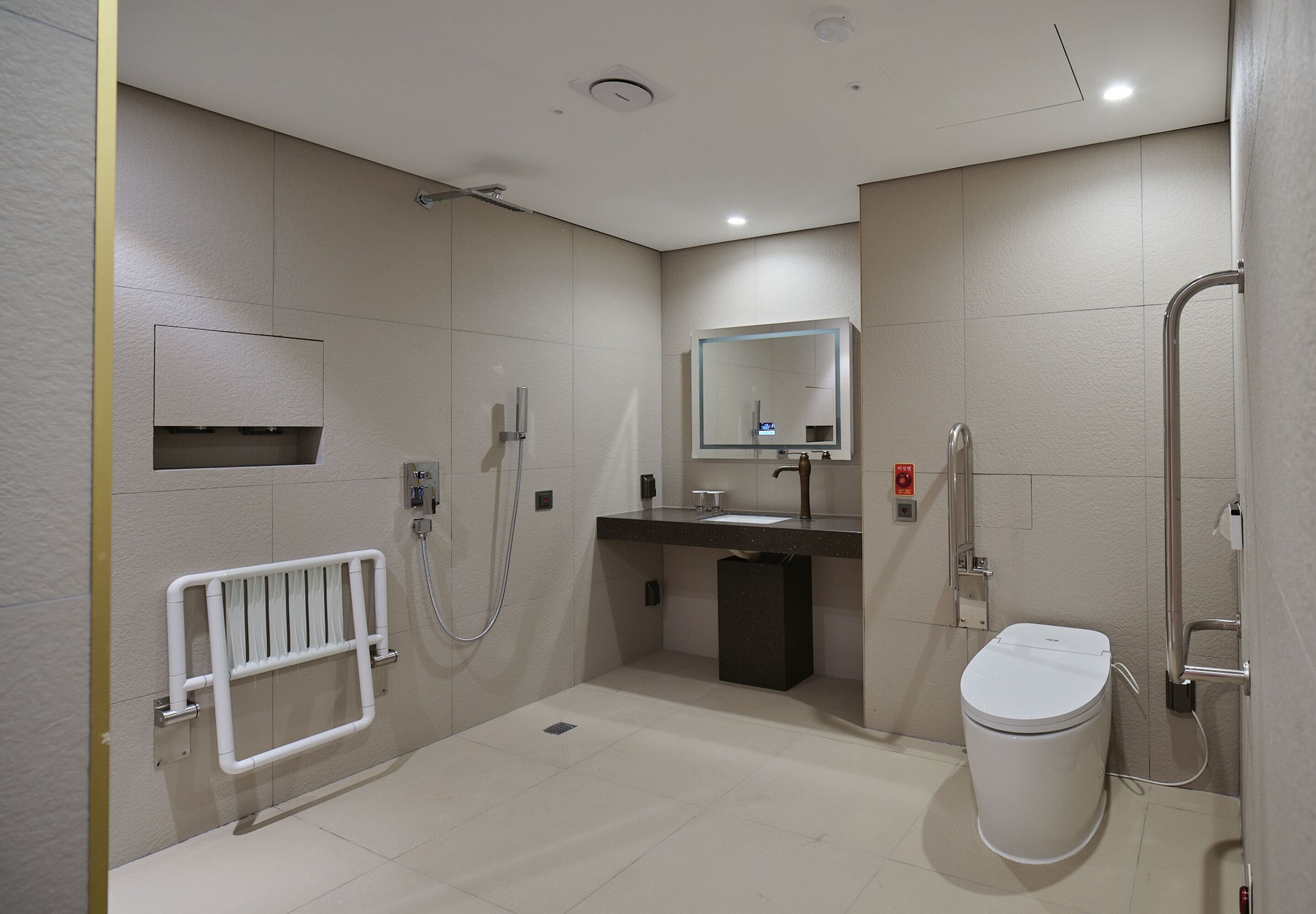 A modern bathroom with a shower, toilet, sink, and a mirror.