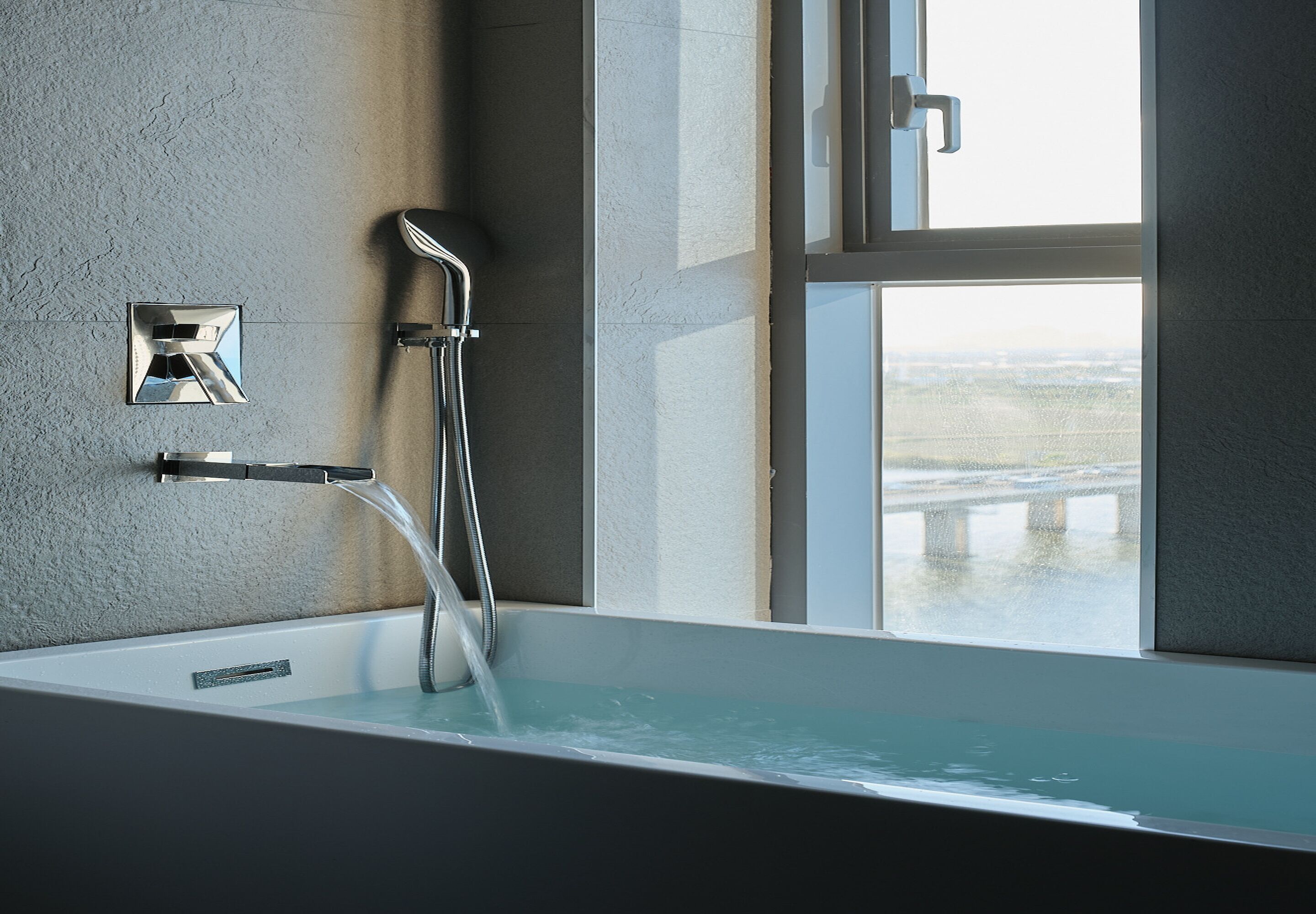 Une salle de bain moderne équipée d’une baignoire, d’une douche et d’une fenêtre donnant sur l’extérieur.