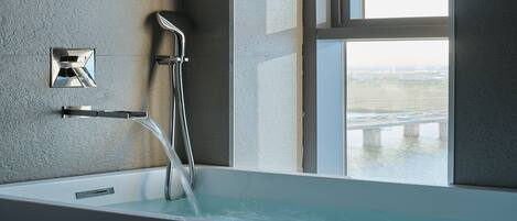 Une salle de bain moderne équipée d’une baignoire, d’une douche et d’une fenêtre donnant sur l’extérieur.