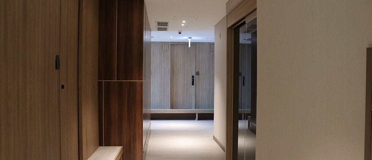 Un pasillo con paneles de madera, un banco y una puerta con manija.