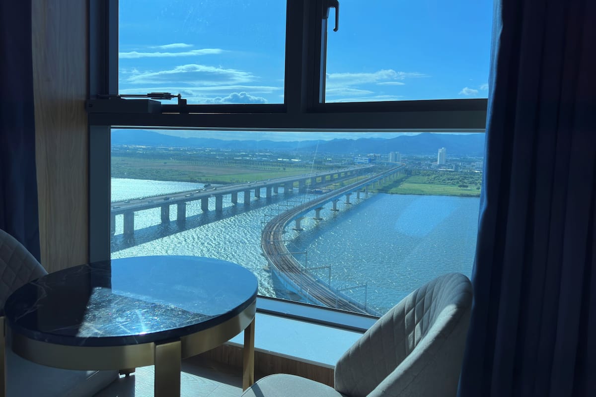 A room with a large window overlooking a bridge and a river.