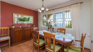 Un comedor con una mesa de madera, sillas, un banco y un armario.