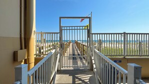 A gated entrance to a beach area with a clear view of the ocean. - Crystal Shores West 701 Corner Condo Wraparound Balcony | Indoor & Outdoor Pools | Beach Getaways (Gulf Shores)