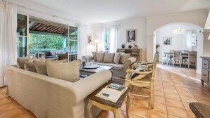 Un salón amplio con sofá, mesa de centro y mesa de comedor.