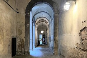 A corridor with arched ceilings and a light fixture on the wall. - CASA CONTI – near Piazza del Campo (Siena)