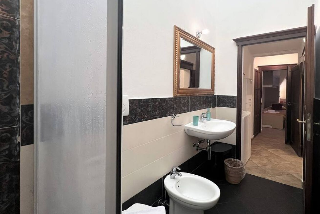 A bathroom with a white sink, a bidet, and a mirror.