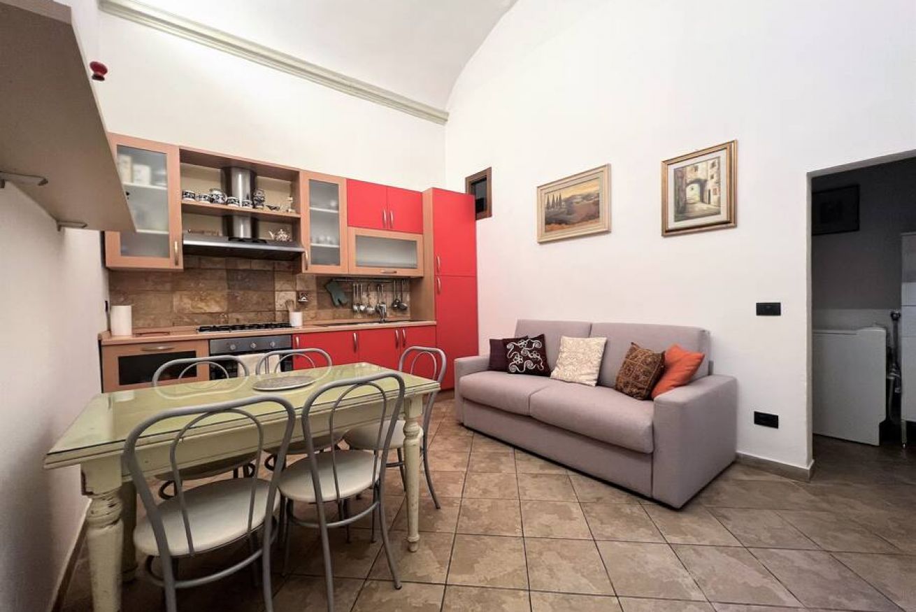 A compact living space with a kitchenette, dining area, and a sofa.