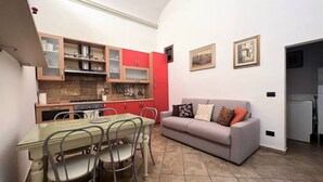 A compact living space with a kitchenette, dining area, and a sofa. - CASA CONTI-nearby Piazza del Campo (Siena)