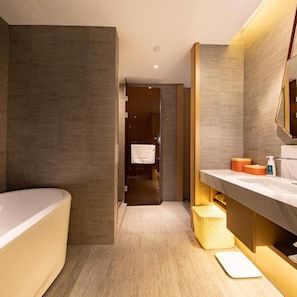A modern bathroom with a bathtub, a vanity with a mirror, and a shower area.
