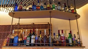 Una zona de bar con varias estanterías llenas de botellas de licor.