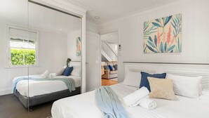 A hotel room with two beds, a large window, and a staircase leading to another room. - Family Home in Balmoral - Family Stays (Balmoral)