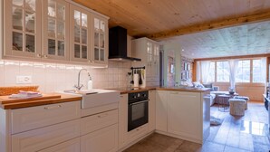 A modern kitchen with white cabinetry, a wooden countertop, and a built-in oven. - Chalet Bijou+ 1 OG by Interhome (Lenk)
