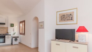 Een moderne keuken met een wasmachine, een televisie op een kast en een rode lamp.
