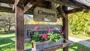 Un panneau en bois indiquant l’entrée de la ferme, avec les mots « Eingang » et « Farmenwunderland ».