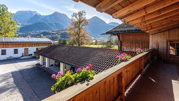 Un bâtiment en bois doté d’un balcon donnant sur un paysage montagneux.