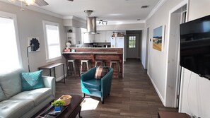 Una sala moderna con un sofá, una mesa de centro y un sillón azul.