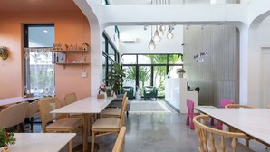 Un moderno vestíbulo de hotel con mostrador de recepción, zona de estar y grandes ventanales que ofrecen vistas al exterior.
