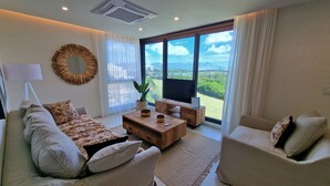 Una sala moderna con un sofá, sillones, una mesita de centro y un televisor.