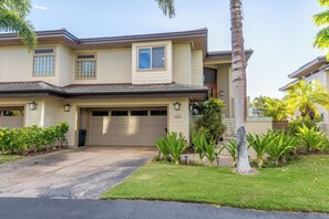A two-story house with a garage, a well-maintained lawn, and various plants. - Ohana Paradise@ Mauna Lani Villages, private beach club access (Waimea)