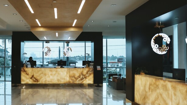 A modern reception area with a marble counter, large windows, and a view of the cityscape. - Lovely waterfront condo (Hollywood)