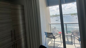 A balcony with a view of the sea, a chair, and a table. - Lovely waterfront condo (Hollywood)