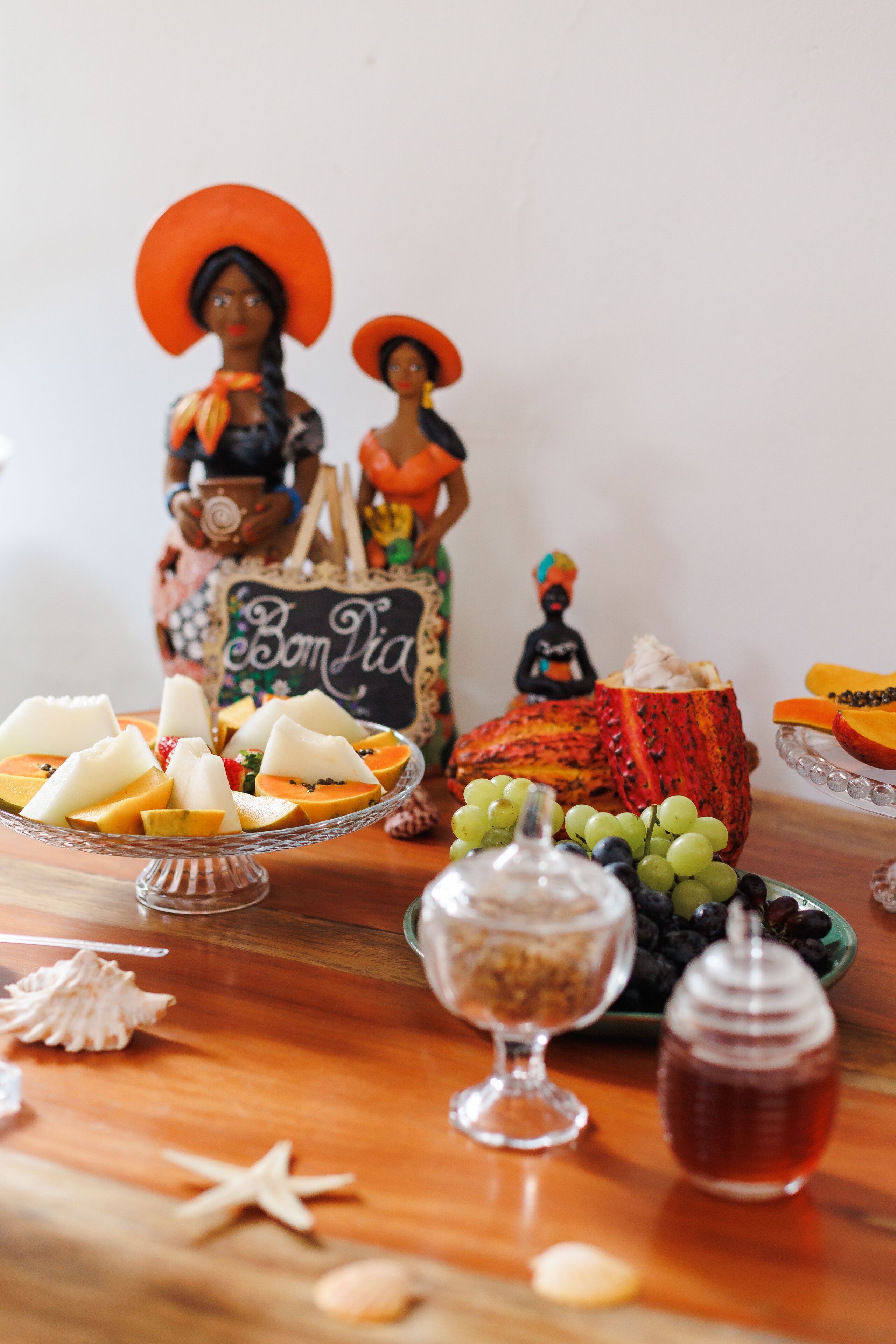 A table with various food items and decorative objects, including a sign that reads "Bon Dia".