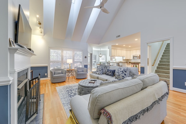 A spacious living room with a fireplace, a large sofa, and a dining area.