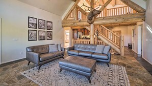 A spacious living room with leather sofas, a stone floor, and a wooden staircase. - Mtn-View Gem w/ Fire Pit & Deck in Payson (Payson)