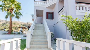 A staircase leading to a building with white railings and a palm tree in the foreground. - Sound Of The Mountain Chania (Chania)