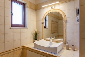 A bathroom with a large mirror, a sink, and a window. - Sound Of The Mountain Chania (Chania)