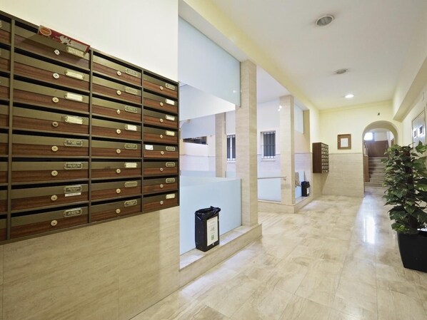 Un hall d’hôtel avec un classeur en bois, un comptoir d’accueil et un escalier menant à un autre étage.